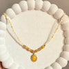 Yellow Beaded Necklace with Sunburst Oval Pendant.